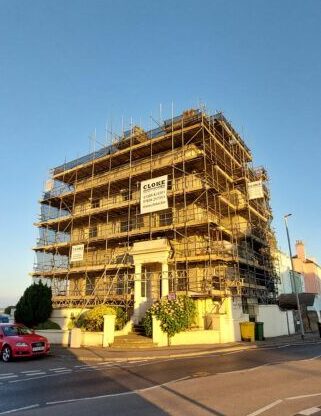 Nearby, scaffolded hotel at sunset